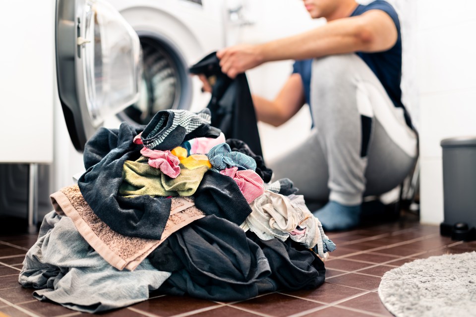 a man is kneeling down next to a pile of clothes