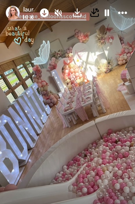 a room filled with pink and white balloons and a sign that says what a beautiful day