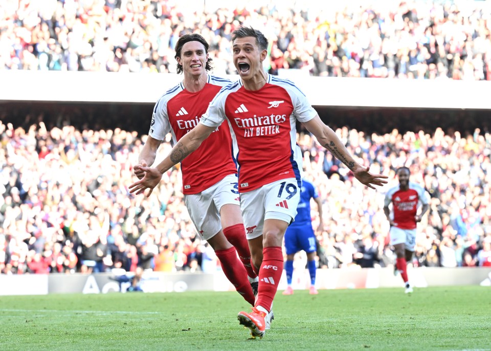 two soccer players wearing emirates fly better jerseys celebrate