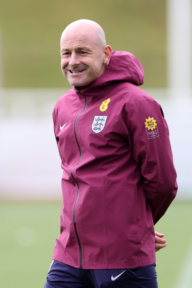 a man wearing a maroon nike jacket with a yellow badge that says beach hut