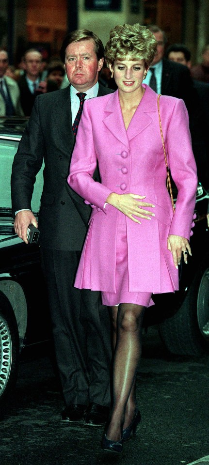 a woman in a pink suit is standing next to a man in a suit