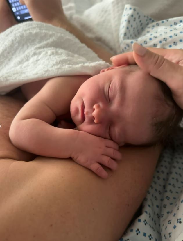 a newborn baby is sleeping on a person 's chest