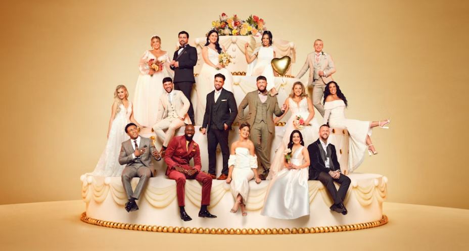 a group of people sitting on top of a wedding cake