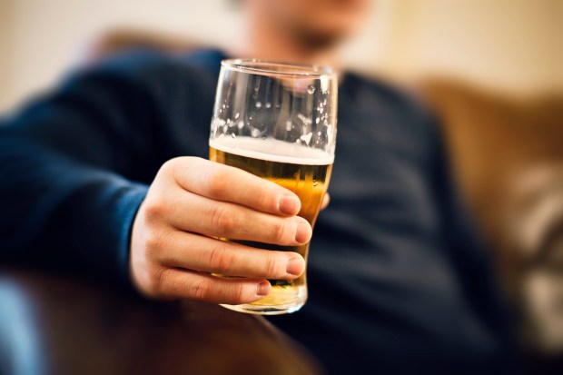 a man is holding a glass of beer in his hand