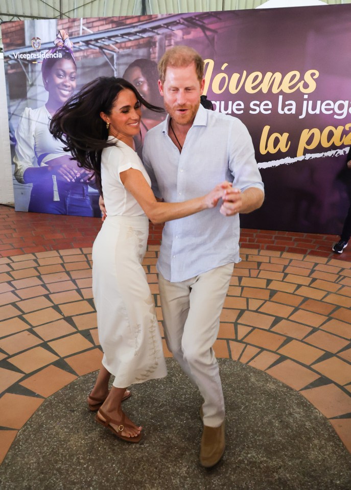 a man and woman are dancing in front of a sign that says jovenes que se la juega la paz