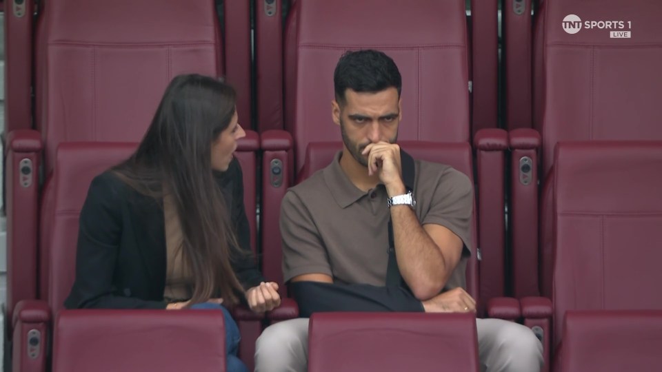 a man and a woman sit in a stadium watching tnt sports 1 live