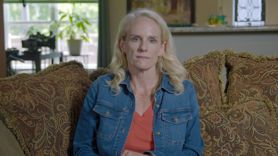 a woman in a denim jacket sits on a couch