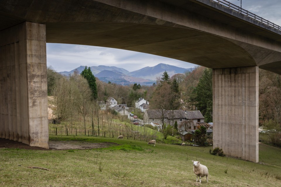 T51KE6 A66 Keswick bypass bridge framing the Lake District landscape.