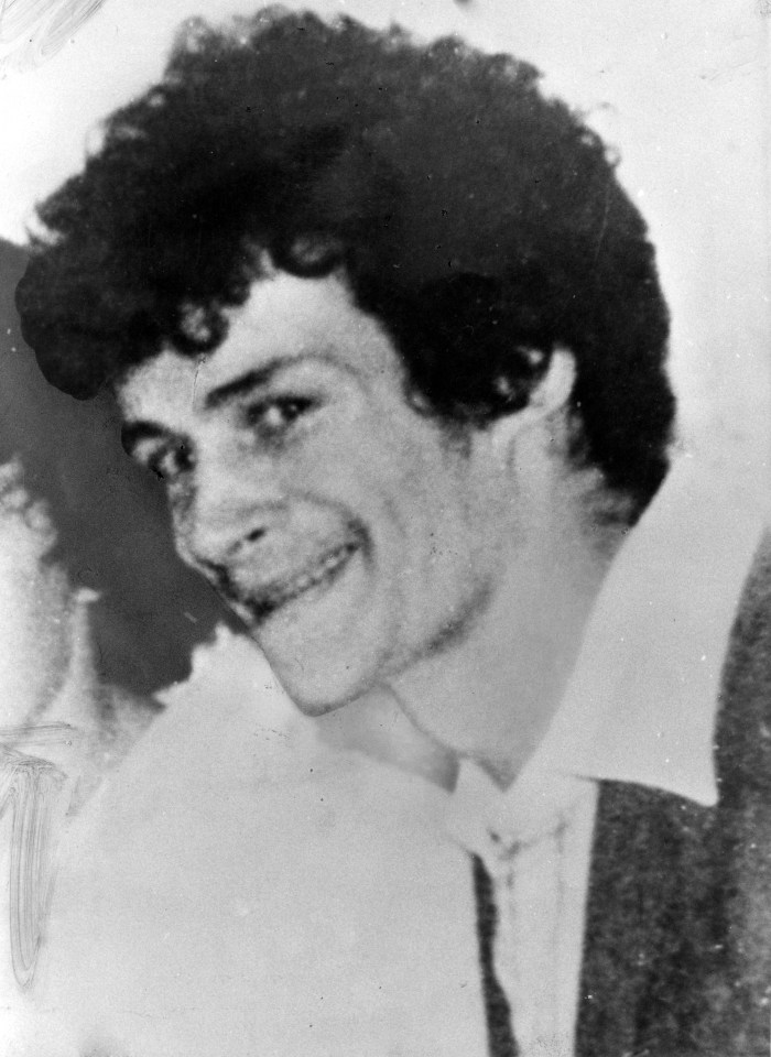 a man with curly hair is smiling in a black and white photo