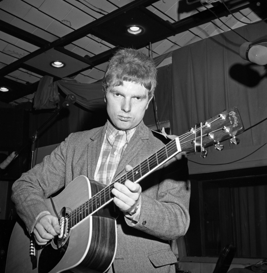 a man playing an acoustic guitar with a martin logo on the headstock