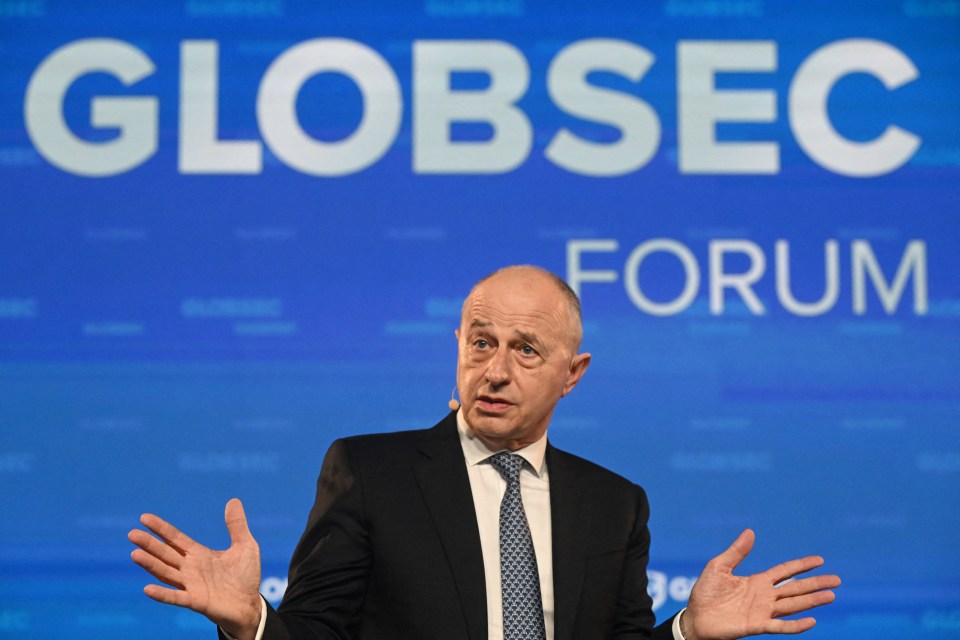 a man stands in front of a sign that says globsec forum