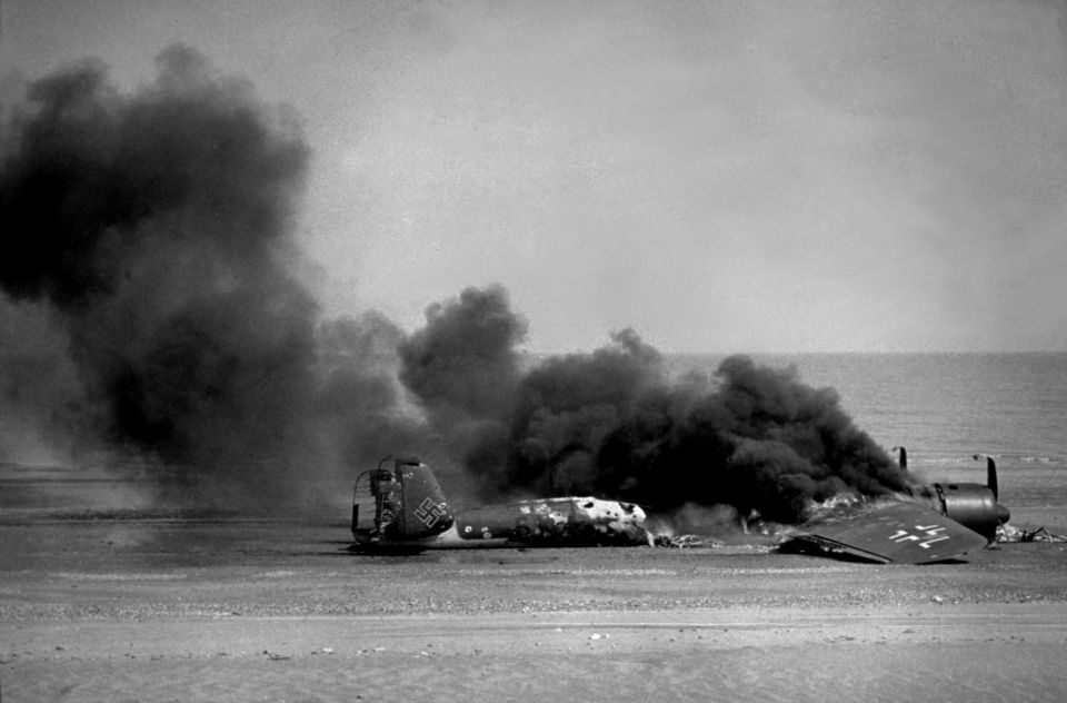 A Nazi Dornier 17 burns on an English beach after being shot down by a Lewis gun