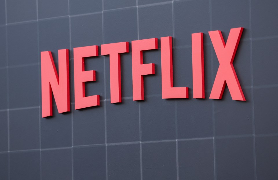 a red netflix logo on a black tiled wall