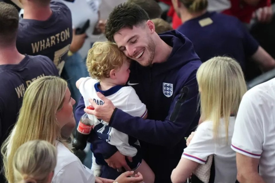 a man holding a baby wearing a shirt that says dad