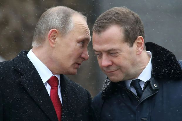 two men in suits and ties are looking at each other