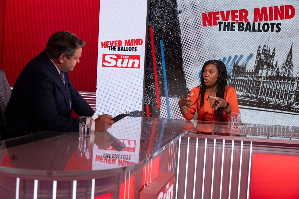 a man and a woman are sitting in front of a sign that says never mind the ballots