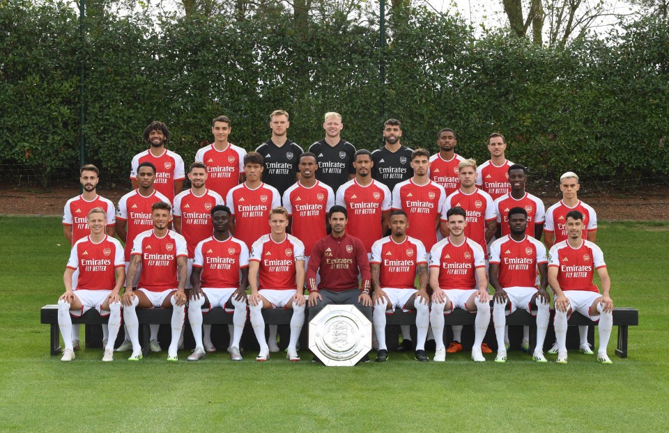 a soccer team poses for a team photo wearing emirates fly better jerseys