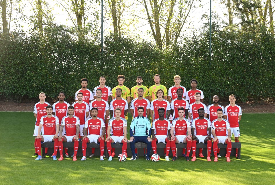 a group of soccer players are posing for a team photo wearing red jerseys that say emirates fly better