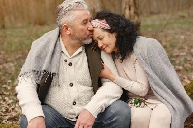 a man is kissing a woman on the forehead