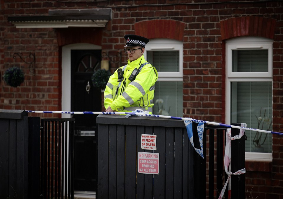 An officer stands guard outside the property