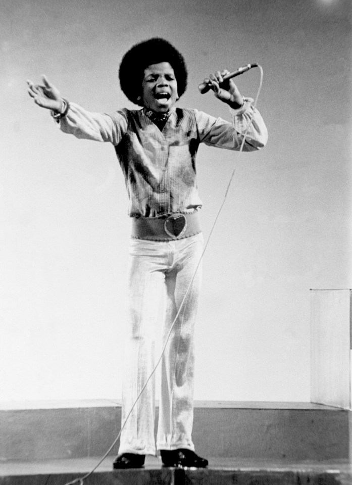 a black and white photo of a man singing into a microphone