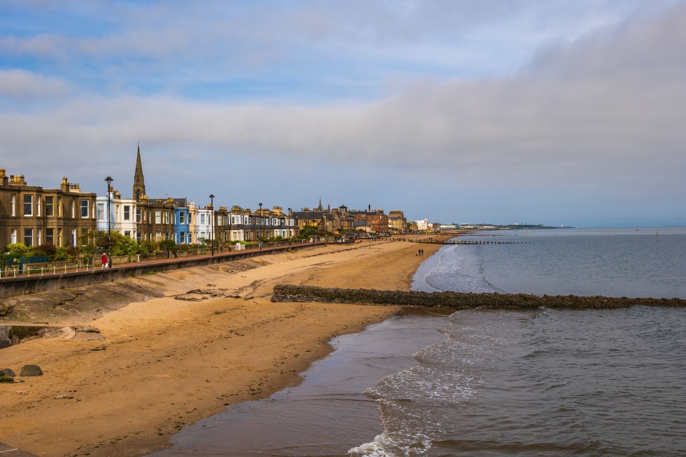 a beach with a row of houses along the shore