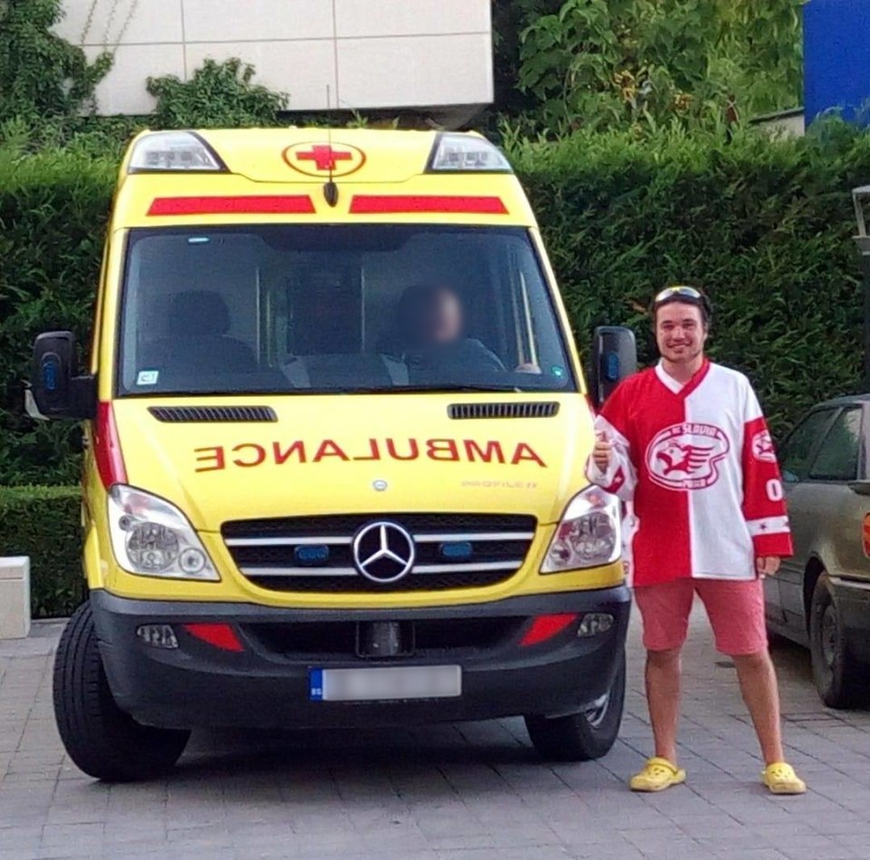 a man stands in front of an ambulance that says ambulance on the front