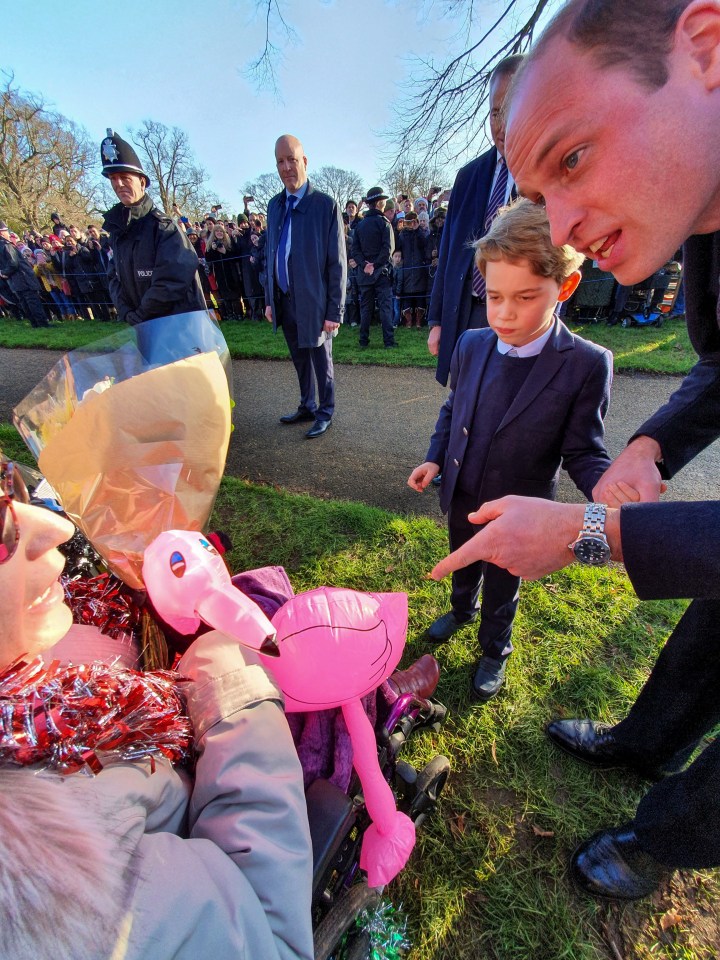 a man in a suit talks to a young boy in a wheelchair