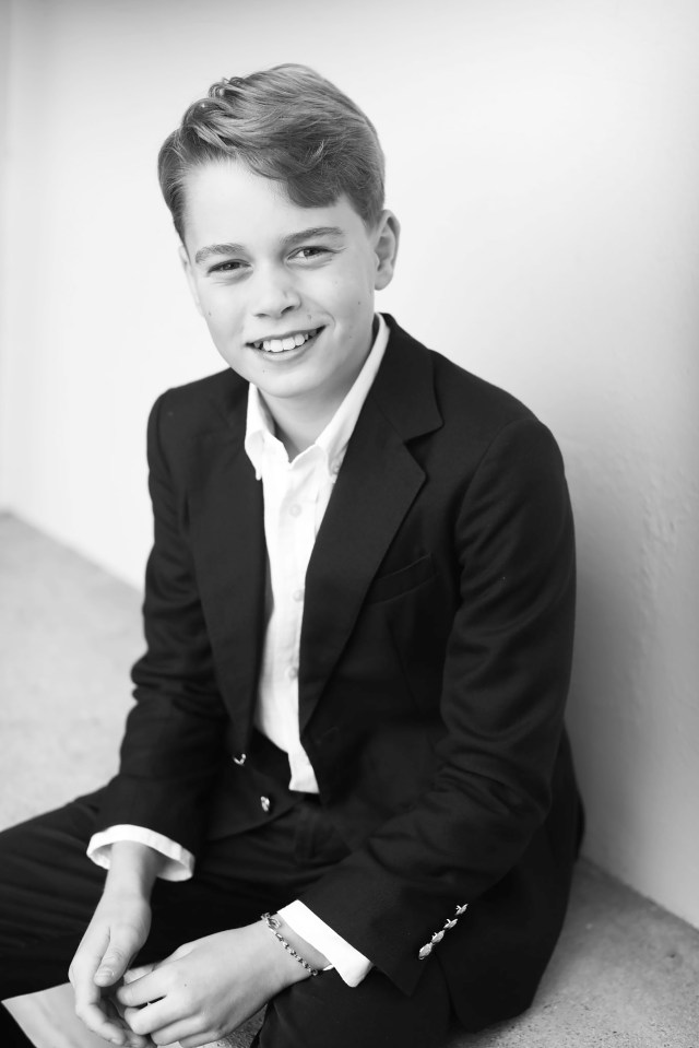 a young boy in a suit and white shirt smiles for the camera