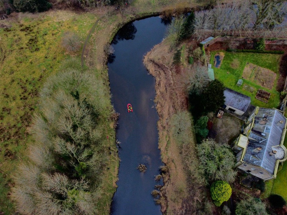 an aerial view of a river with a boat in it