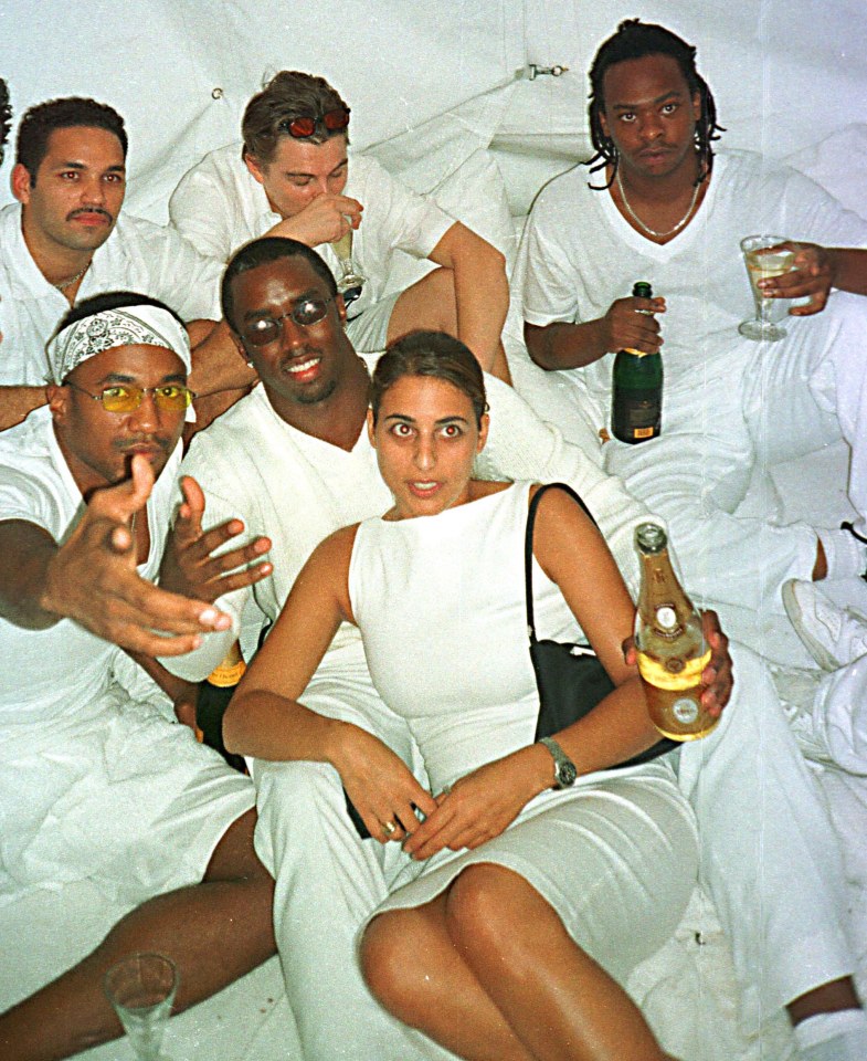 a woman in a white dress is holding a bottle of champagne