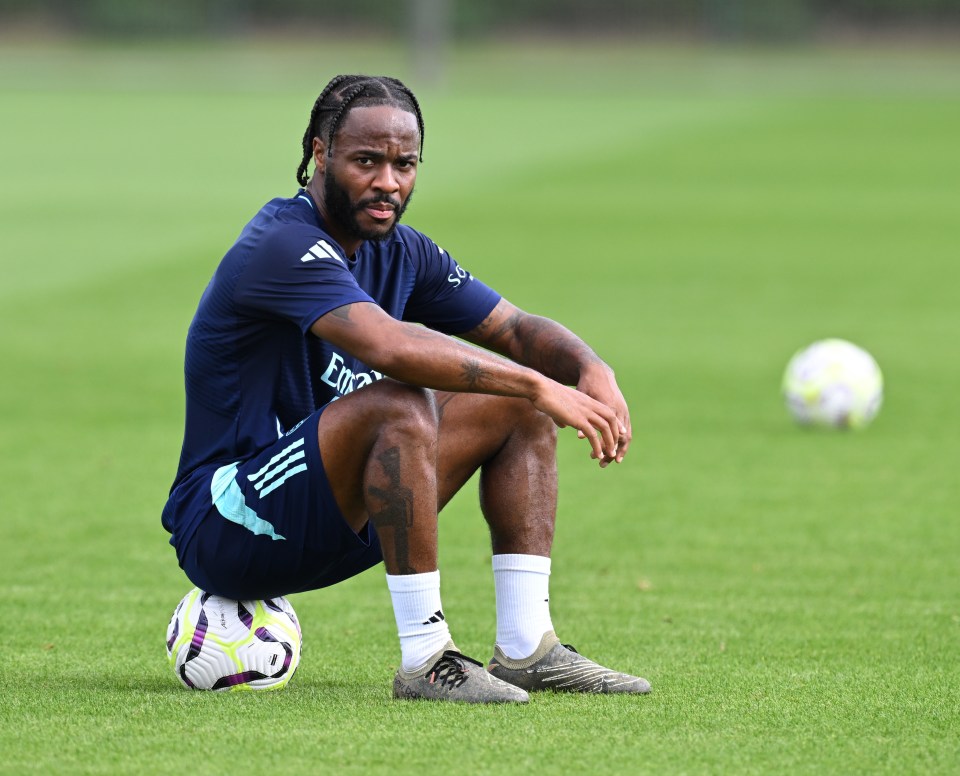 a man sitting on a soccer ball wearing an adidas shirt