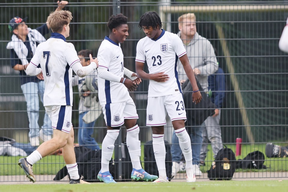 a soccer player wearing number 23 shakes hands with another player