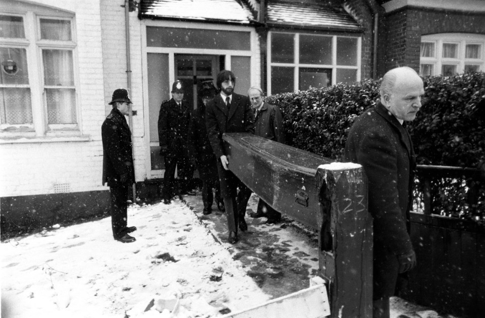 a black and white photo of a group of men carrying a coffin