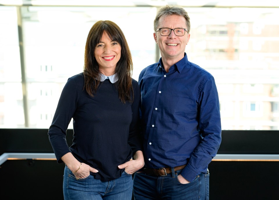 a man and a woman standing next to each other with their hands in their pockets