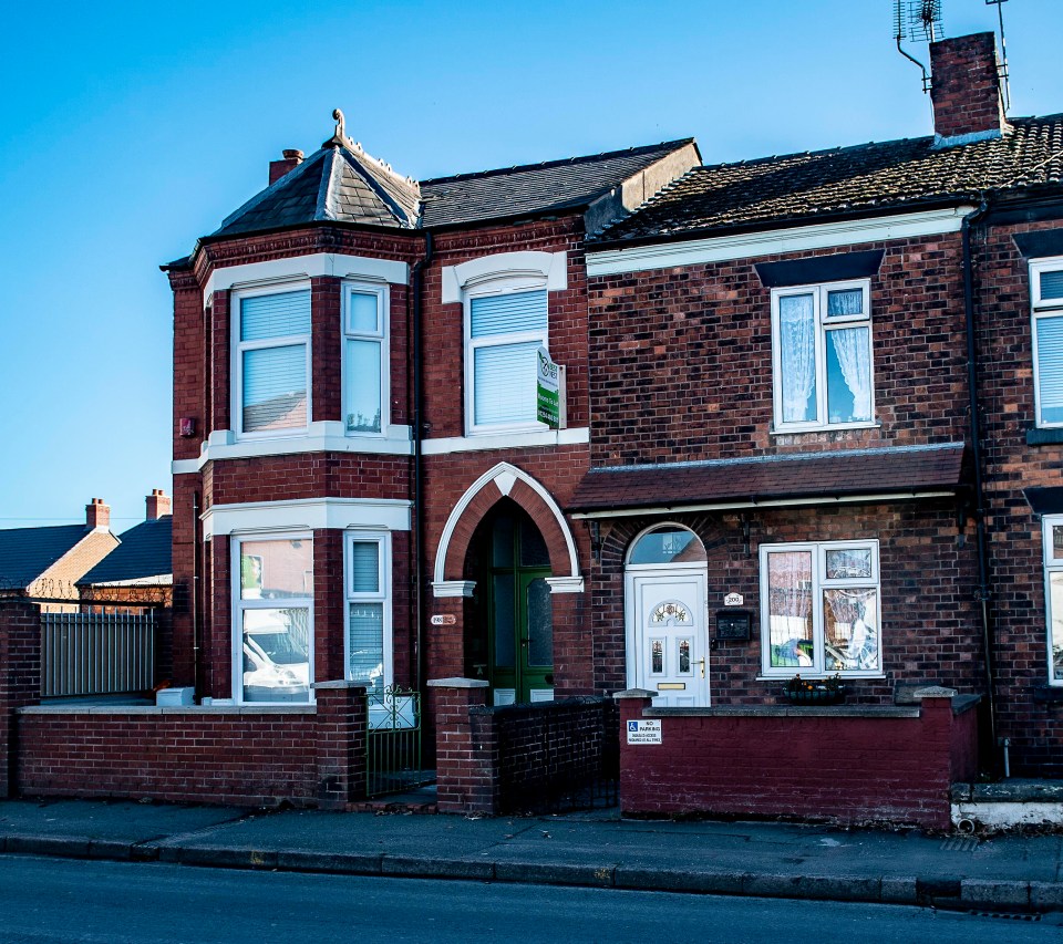 a red brick house with a sign on the side that says ' for sale '