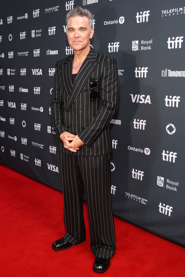 a man in a suit stands in front of a wall that says tiff