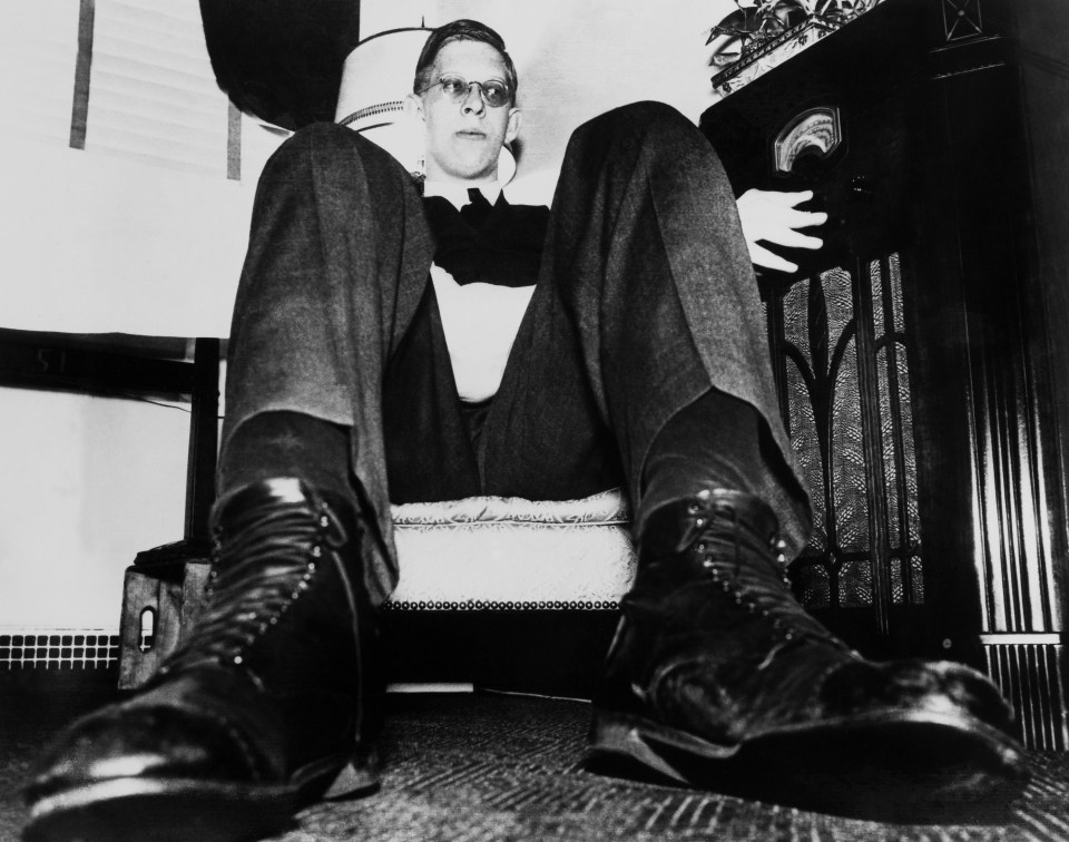 a black and white photo of a man sitting on a chair