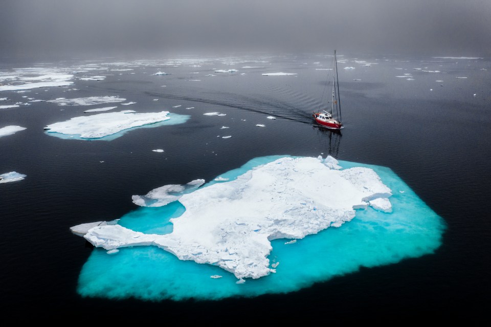 a boat is floating on top of a large iceberg