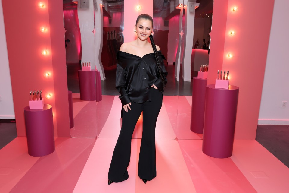 a woman in a black off the shoulder top and black pants