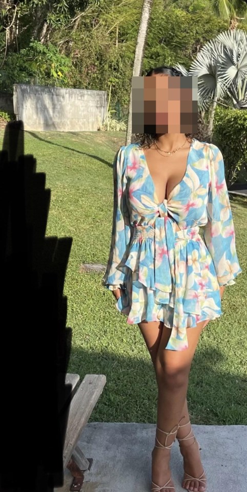 a woman in a blue and white floral dress is standing in the grass