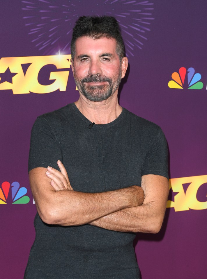 a man with his arms crossed in front of a sign that says ag