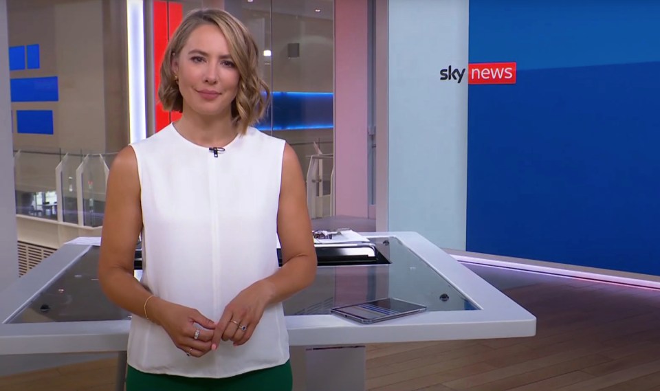 a woman stands in front of a sign that says sky news