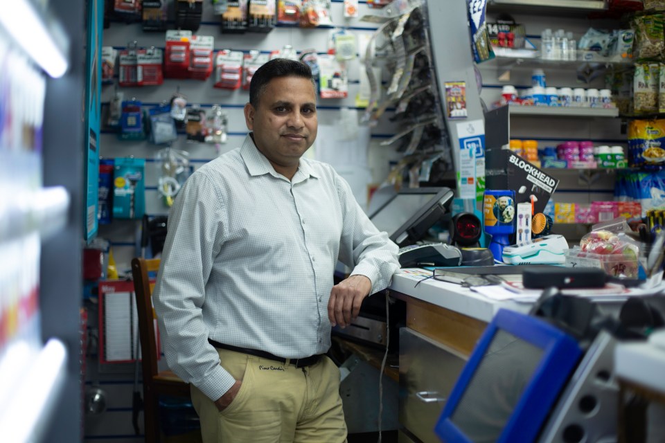 a man in a store with a sign that says blockhead on it