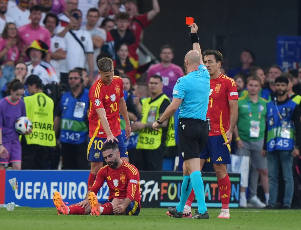 a referee gives a red card to a spanish player