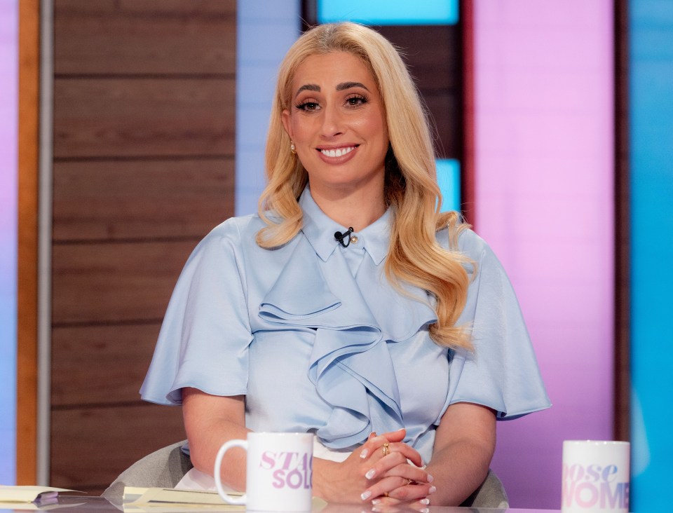 a woman sits at a table with a mug that says stay home