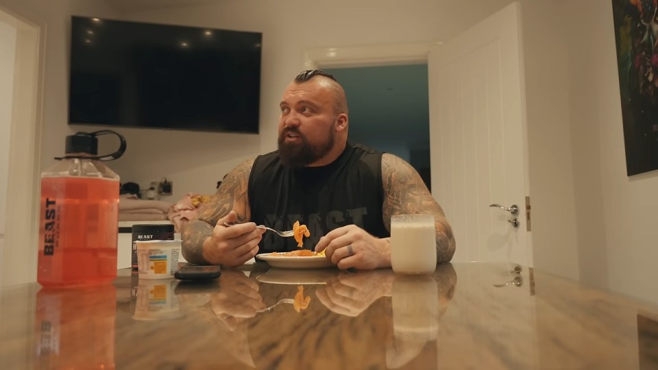 a man sitting at a table with a bottle that says beast on it