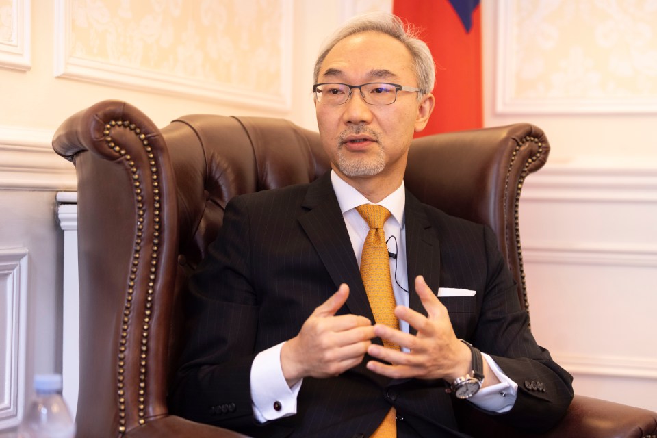 a man in a suit and tie is sitting in a chair