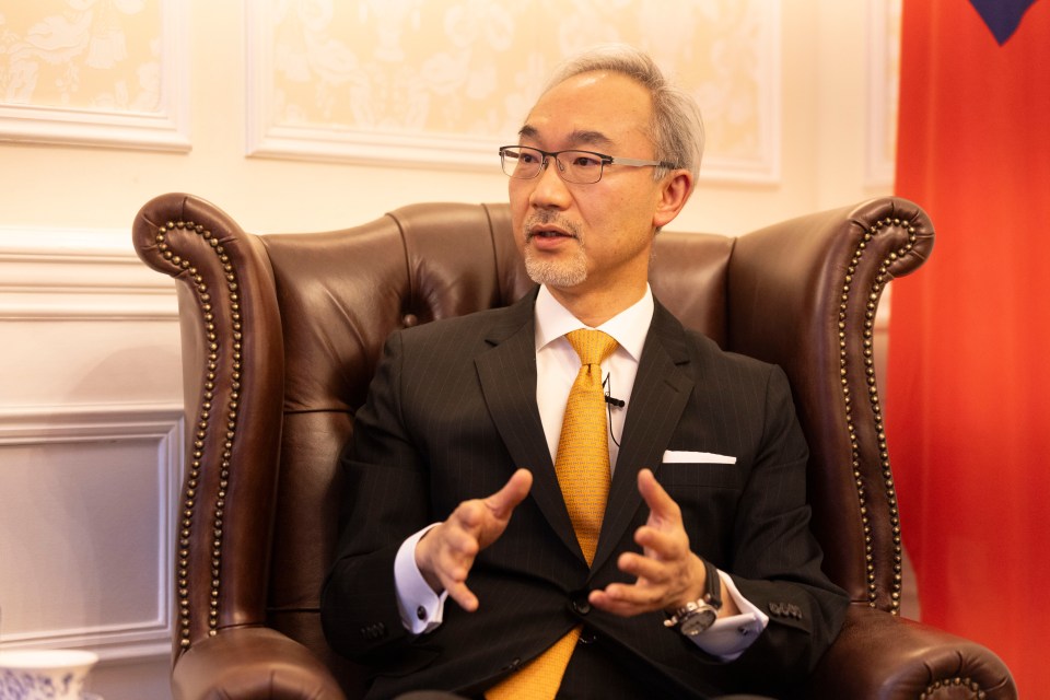 a man in a suit and tie is sitting in a chair