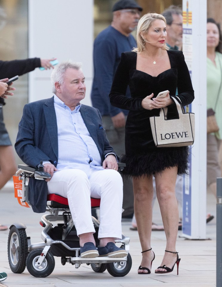 a man in a wheelchair with a loewe bag